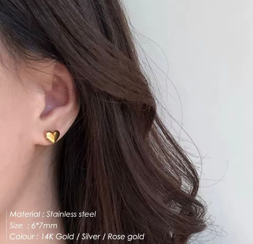 Modelo luciendo arete de corazón dorado minimalista de Pretty Women RD.