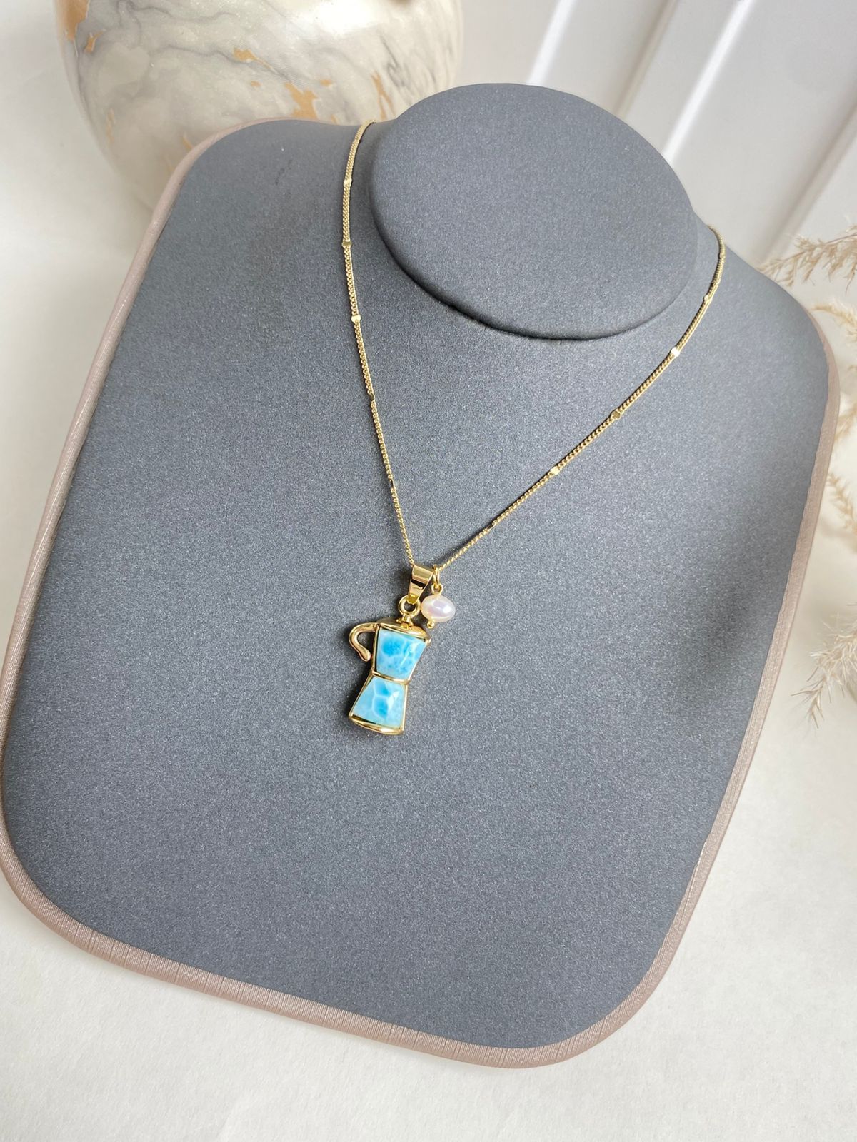 Collar cafetera moka azul con perla en acabado dorado