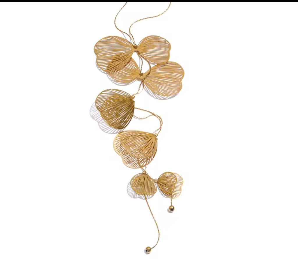 Collar largo orquidea dorado sobre fondo blanco