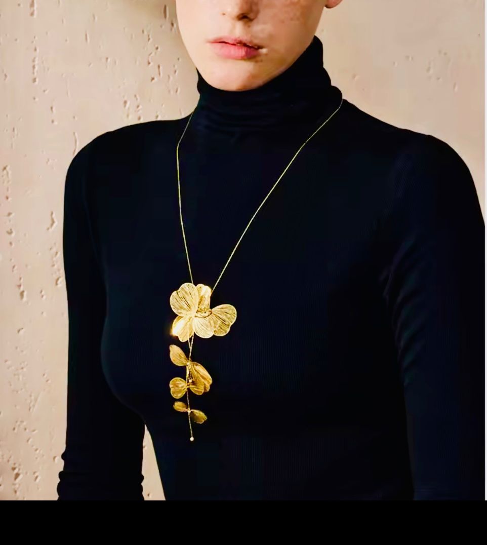 Collar largo orquidea dorado puesto en modelo